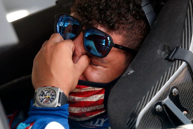 Driver Bubba Wallace, right, is overcome with emotion as he sits in his car prior to the start of the race Monday, June 22, 2020. On Sunday, a noose was found in the garage of Wallace, NASCAR's only Black driver. The FBI is investigating.
