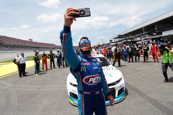 Driver Bubba Wallace takes a selfie with himself and other drivers that pushed his car to the front in the pits.