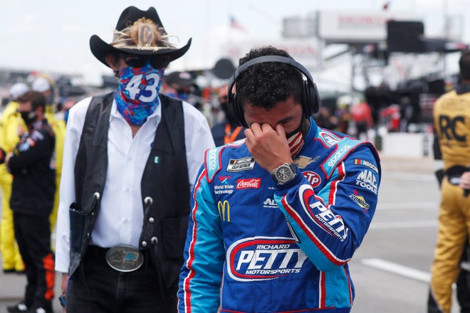 Driver Bubba Wallace, right, is overcome with emotion as he and team owner Richard Petty walk to his car in the pits.