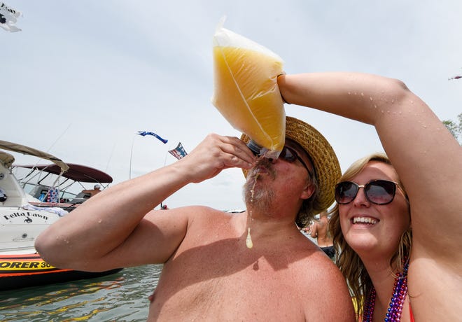 Mike Campbell gets a cocktail from his daughter Justine Campbell, both from Gregory, Mich., during the annual Jobbie Nooner at Gull Island on Lake St. Clair, Friday, June 26, 2020.