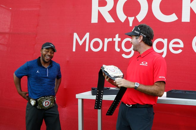 Harold Varner III, left, and Bubba Watson show off the winner's belts after their exhibition victory against Jason Day and Wesley Bryan.