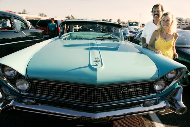 Adrienne Turner with her robin's egg blue 1959 Lincoln Continental Mark IV and her boyfriend Danny Krawczyk hang out in a parking lot at 13 Mile and Woodward Ave. in Royal Oak during the week of Dream Cruise on August 16, 2006.