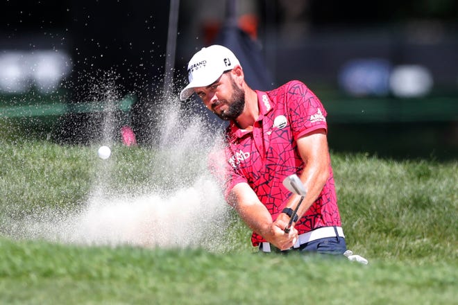 Troy Merritt hits from the bunker at No. 14.