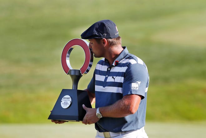 Bryson DeChambeau kisses the Rocket Mortgage Classic golf tournament trophy Sunday, July 5, 2020, at Detroit Golf Club in Detroit. DeChambeau won the tournament by three strokes for his first victory of the season and sixth overall.