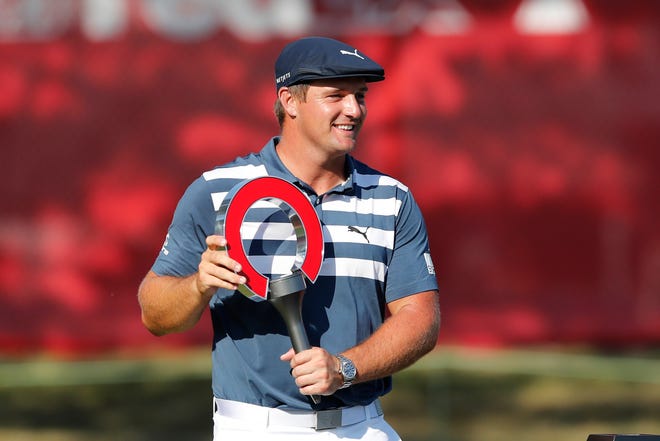 Bryson DeChambeau holds the Rocket Mortgage Classic golf tournament trophy Sunday, July 5, 2020, at Detroit Golf Club in Detroit.