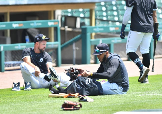 From left, Tigers' Jordy Mercer and Harold Castro change their shoes between batting and fielding practice.  Detroit Tigers work out at Comerica Park in Detroit on July 6, 2020.