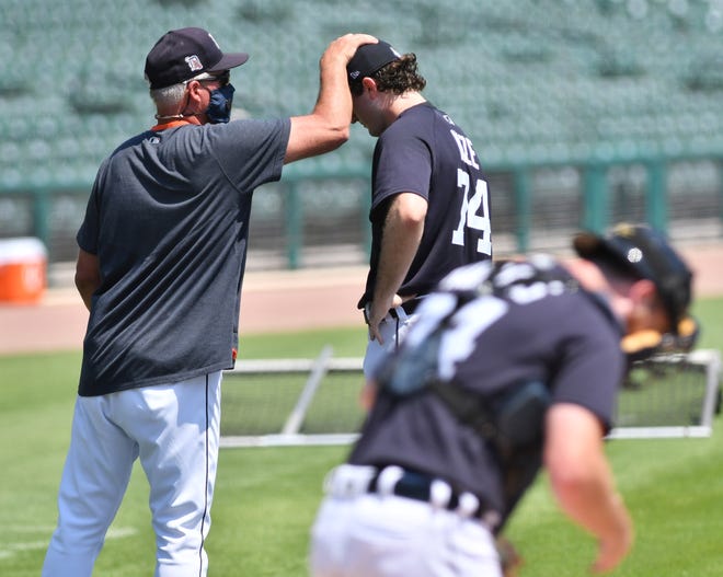 Tigers pitching coach Rick Anderson pats the cap of pitcher Casey Mize after Mize threw live batting practice.  Detroit Tigers work out at Comerica Park in Detroit on July 6, 2020.