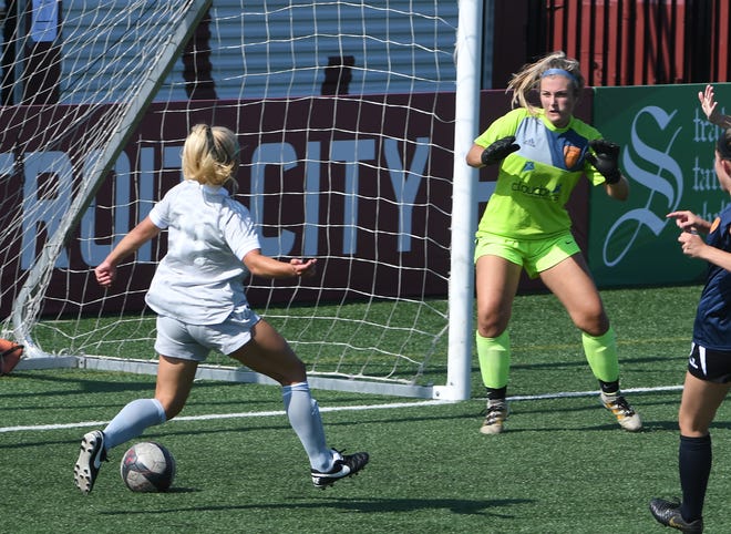 Midwest United FC ' s Stephanie " Stitch " Currie finds herself in the right place at the right time, putting in a crossing pass behind Livonia City FC goalie Jordan Anheuser for her second goal in the first half.