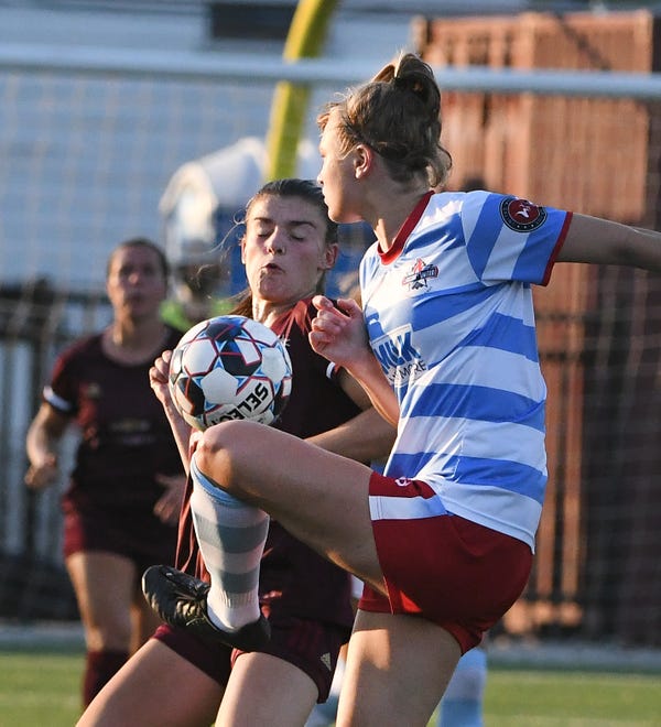 Detroit City FC's Bri Rogers and Lansing United's Abigail Gilmore battle for a loose ball in the first half.