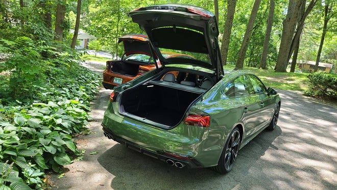 Despite its smaller size, the 2020 Audi S5 Sportback, right, offers more cargo room than the 2020 Dodge Charger Scat Pack thanks to its big hatchback.