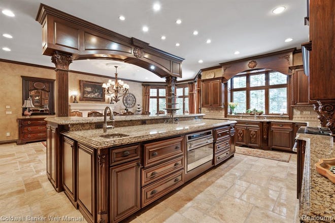 Travertine floors lead to a grand room and Tuscan designed chef's kitchen with granite, and high-end appliances and cabinetry.