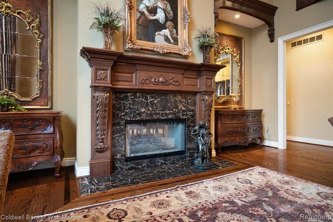 One of the living spaces with hardwood floors and marble fireplace.