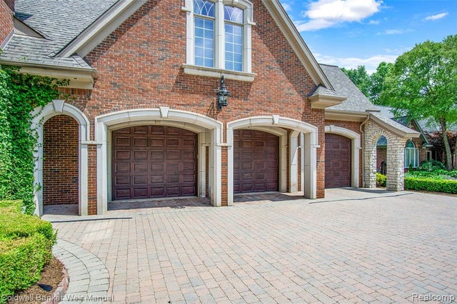 A courtyard entrance with a four-car garage and well-manicured landscape provides a grand entrance to the huge foyer.