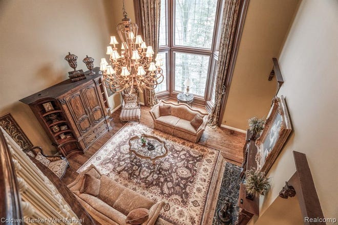 One of the living spaces with hardwood floors, a motorized chandelier, extra large windows and fireplace.
