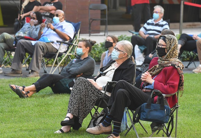 Marcia Burrows and Elizabeth Sims listen to the Detroit Symphony Orchestra's string trio of Kimberly Kaloyanides Kennedy on violin, Eric Nowlin on viola and Wei Yu on cello at Sosnick Courtyard in Detroit, Michigan on August 5, 2020.