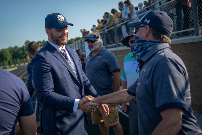 Rocco Spindler, left, shakes hands with Clarkston football head coach Kurt Richardson after Rocco Spindler’s commitment to Notre Dame during his college decision choice at Clarkston High School in Clarkston on Aug. 8, 2020.