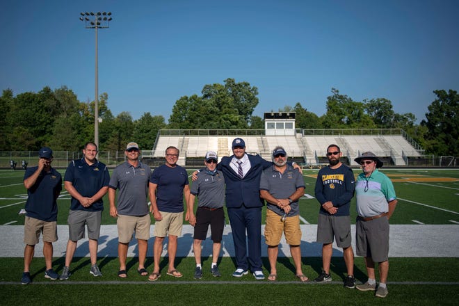 Rocco Spindler poses for a photo with past and former football coaching staff after Spindler’s commitment to Notre Dame during his college decision choice at Clarkston High School in Clarkston on Aug. 8, 2020.