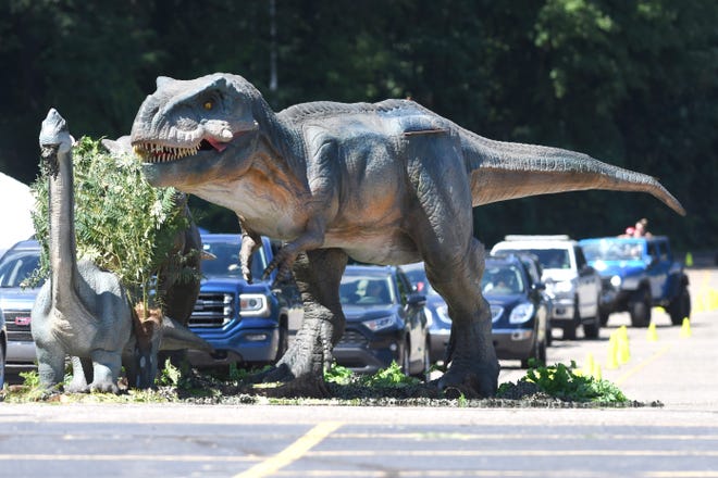Dinosaurs rule the parking lot at DTE Energy Music Theatre during the opening for Jurassic Quest.