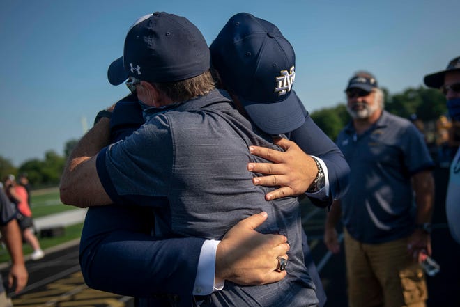 Rocco Spindler, left, embraces Clarkston football head coach Kurt Richardson after Rocco Spindler’s commitment to Notre Dame during his college decision choice at Clarkston High School in Clarkston on Aug. 8, 2020.