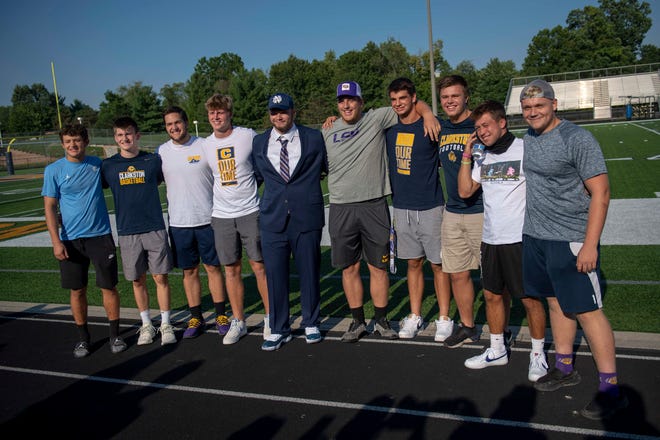 Rocco Spindler poses for a photo with past and former teammates after Spindler’s commitment to Notre Dame during his college decision choice at Clarkston High School in Clarkston on Aug. 8, 2020.