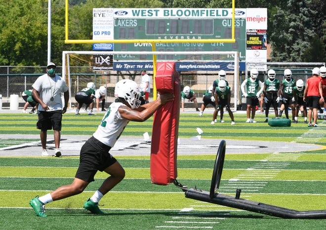 West Bloomfield's Travis Reece moves the sled during drills.