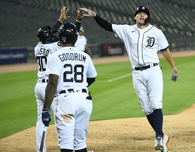 From left, Tigers' Harold Castro celebrates with JaCoby Jones after Jones hit an inside-the-park home run in the seventh inning in front of Niko Goodrum (28).