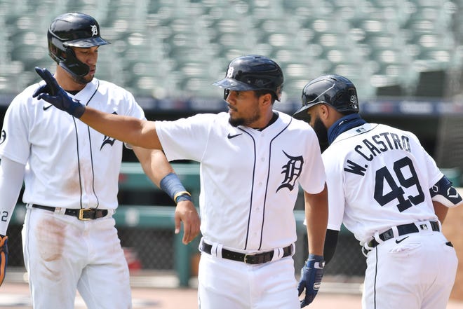 The Tigers' Jeimer Candelario signals out to Grayson Greiner, not shown, after Greiner's double that scored Candelario and Victor Reyes, left, in the fourth inning tying the game 3-3.