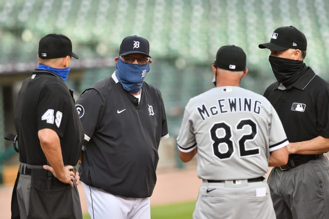 Tigers manager Ron Gardenhire talks with umpires and White Sox bench coach Joe McEwing before the game.