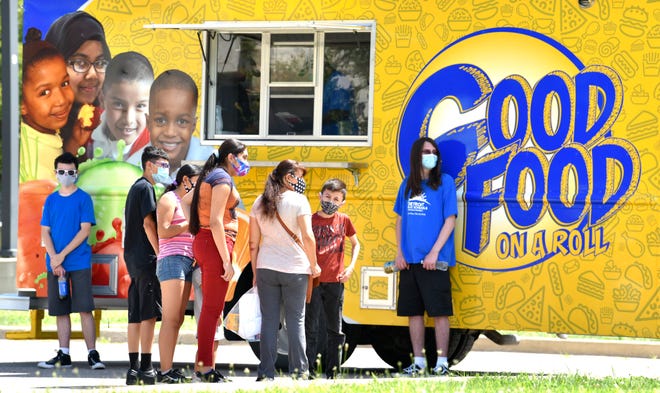 The Olivarez family waits for their food at the Good Food On A Roll food truck from the DPSCD Office of School Nutrition.