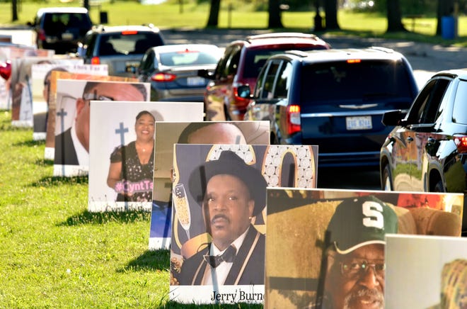Motorists pass portraits of their loved ones during the Detroit Memorial Drive On Belle Isle to honor COVID-19 victims on Memorial Day, Monday, Aug. 31, 2020.