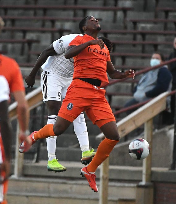 New Amsterdam FC's Zaire Bartley goes up for a header against DCFC's Tendai Jirira in the first half.