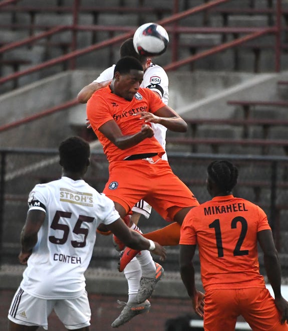 New Amsterdam FC's Zaire Bartley goes up for a header in the first half.