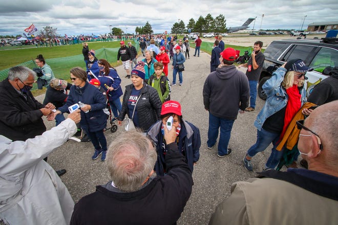 Volunteers perform temperature checks for rally attendees. President Donald Trump makes a campaign stop at an airplane hangar in Freeland, Michigan, on Sept. 10, 2020.