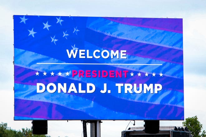 A large digital sign stands in the parking lot outside an airplane hangar before a rally for Donald Trump. President Donald Trump makes a campaign stop at an airplane hangar in Freeland, Michigan on Thursday, September 10, 2020.