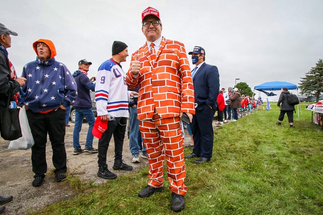 Blake Marnell of San Diego wears his “brick suit” to a rally for Donald Trump. Marnell’s Twitter handle, @brick_suit, and his outfit are to show his support for strong border barriers to reduce the flow of narcotics and human trafficking across the US borders. President Donald Trump makes a campaign stop at an airplane hangar in Freeland, Michigan on Thursday, September 10, 2020.