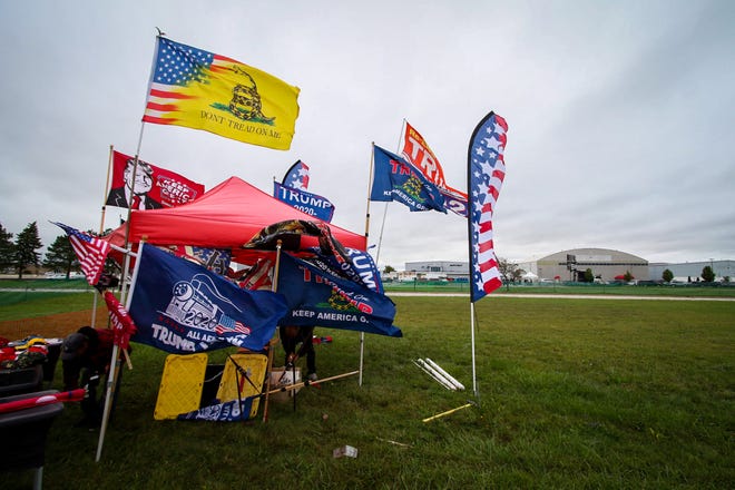 Bright flags contrast the gloomy skies ahead of a rally for Donald Trump. President Donald Trump makes a campaign stop at an airplane hangar in Freeland, Michigan on Thursday, September 10, 2020.