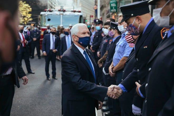Vice President Mike Pence greets firefighters assembled at FDNY Ladder 10 Engine 10  near the 9/11 Memorial on Friday, Sept. 11, 2020, in New York.  Americans are commemorating 9/11 with tributes that have been altered by coronavirus precautions and woven into the presidential campaign, drawing President Donald Trump and Democratic challenger Joe Biden to pay respects at the same memorial without crossing paths.