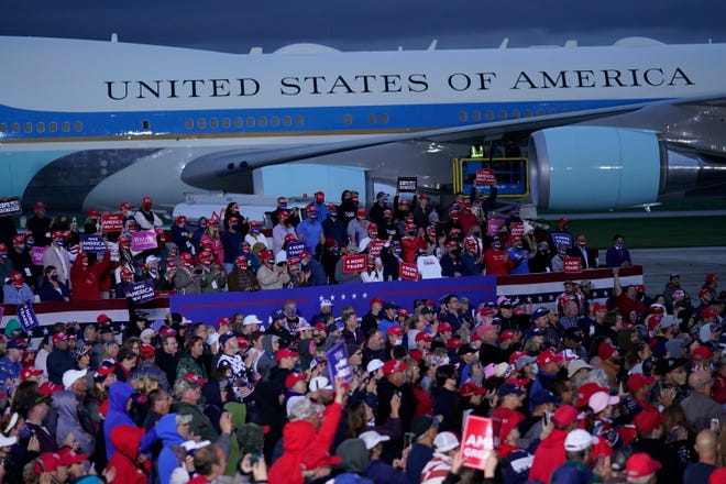 With Air Force One in the background, supporters of President Donald Trump listen as he speaks during a campaign rally at MBS International Airport, Thursday, Sept. 10, 2020, in Freeland, Mich.