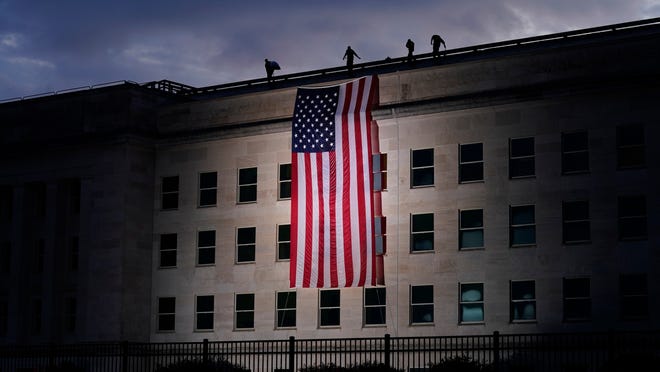A large American flag is unfurled at the Pentagon ahead of ceremonies at the National 9/11 Pentagon Memorial to honor the 184 people killed in the 2001 terrorist attack on the Pentagon, in Washington, Friday Sept. 11, 2020.