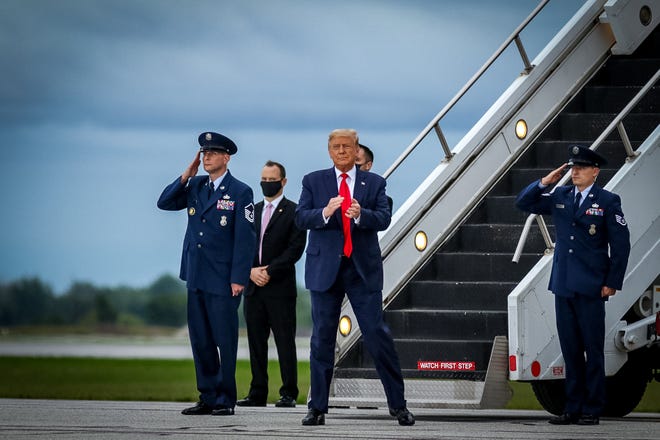 President Trump claps as crowds cheer his entrance. President Donald Trump makes a campaign stop at an airplane hangar in Freeland, Michigan on Thursday, September 10, 2020.