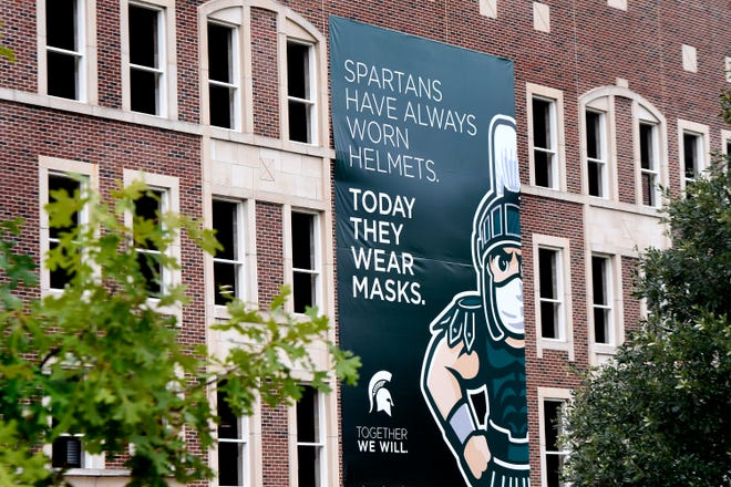 Signs call for face coverings on campus in East Lansing Saturday.