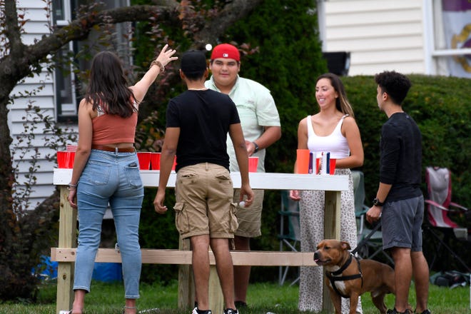 Students and friends gather at a house on Gunson Street, off the Michigan State campus in East Lansing Saturday. The Ingham County Health Department has urged current MSU students to self-quarantine to contain a new COVID outbreak.