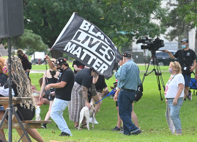 A participant waves a black lives matter flag during the 2020 Detroit Slutwalk  held at Palmer Park.