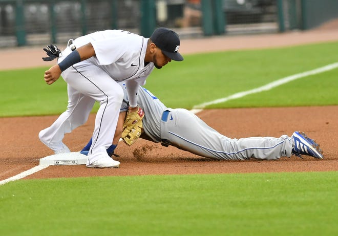 Royals ' Whit Merrifield is safe stealing third with Tigers third baseman Isaac Paredes, left, applying a tag in the first inning.