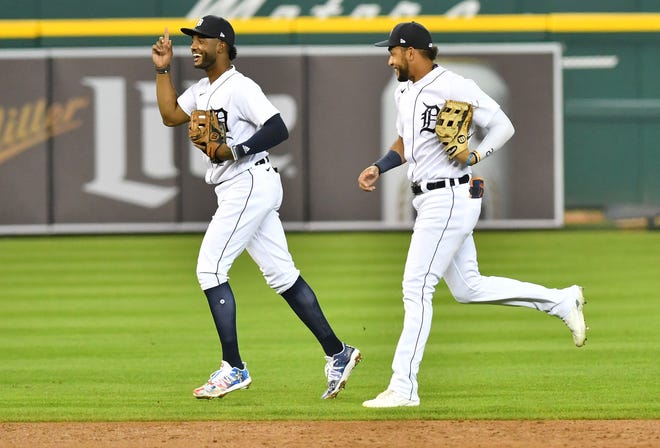 From left, Tigers outfielder Niko Goodrum and Victor Reyes smile while they head to the dugout in the third inning.