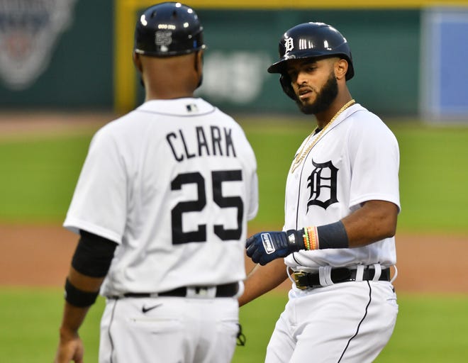 Tigers ' Willi Castro with first base coach Dave Clark after Castro singles in the first inning.
