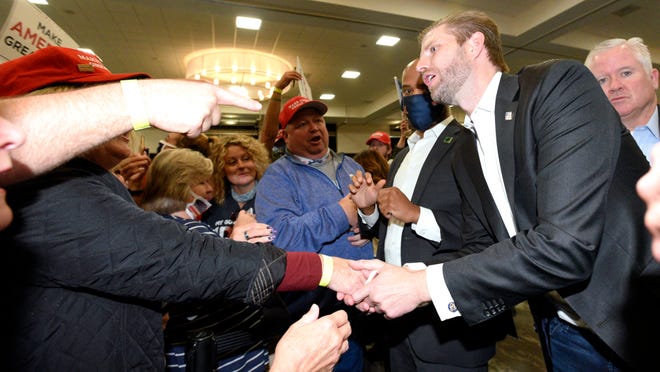 Eric Trump shakes hands with supporters after he speaks.