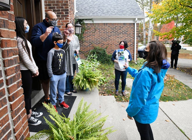 Gov. Gretchen Whitmer, right, and Julia Pulver, candidate for 39th House District, visit the Mangrulkar family while campaigning around West Bloomfield Township on October 18, 2020.