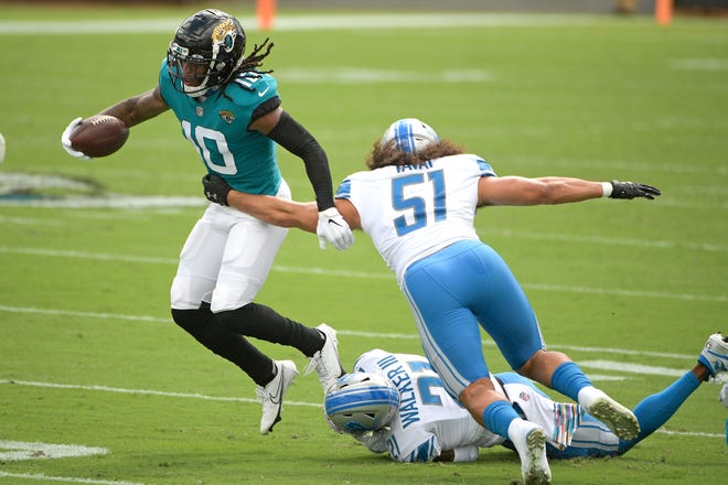 Jaguars wide receiver Laviska Shenault Jr., left, tries to avoid a tackle by Lions linebacker Jahlani Tavai (51) and safety Tracy Walker (21) during the first half.