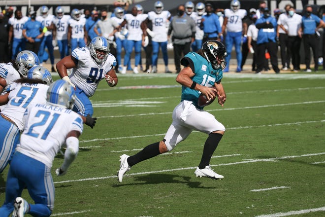 Jaguars quarterback Gardner Minshew II, right, scrambles past the Lions defense for a 6-yard touchdown.